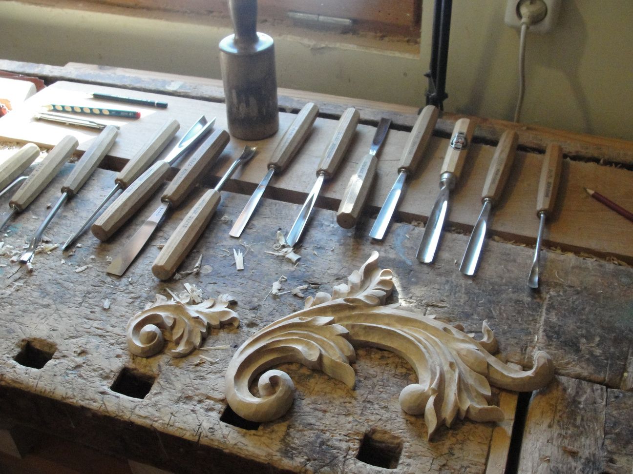 Carving chisels and a scroll ornament on the bench